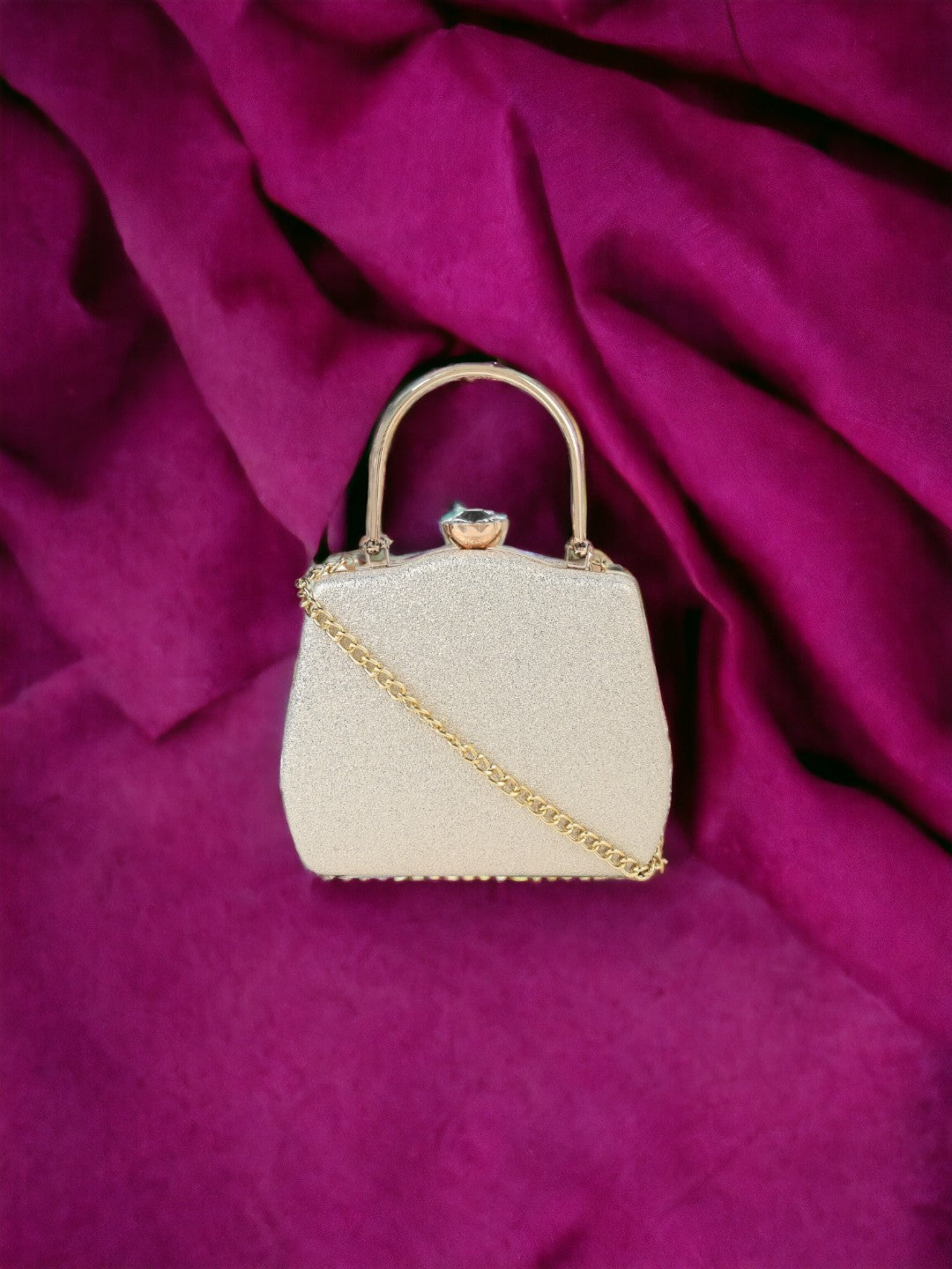 A white Vdesi clutch purse with a shiny surface.