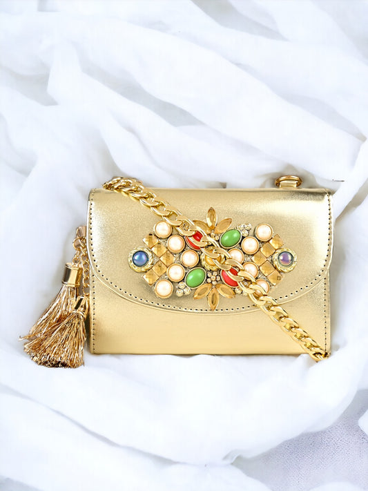 A Vdesi gold clutch on a plain white sheet. 