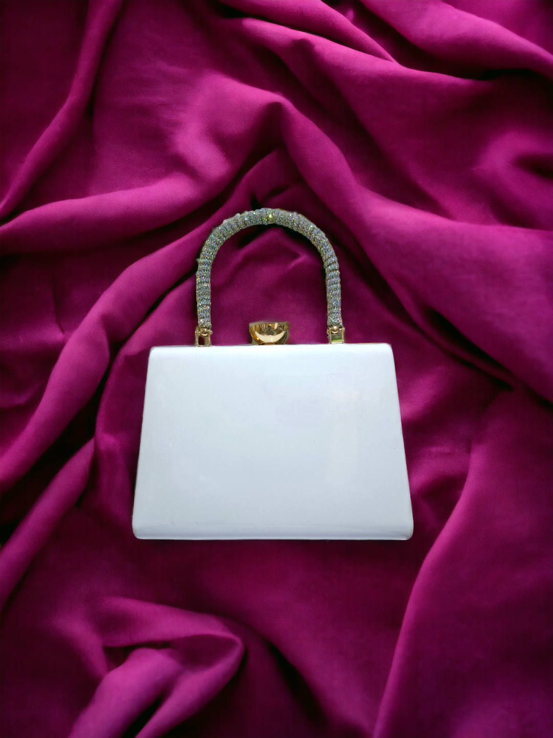 A Vdesi handle clutch on a plain pink background. 