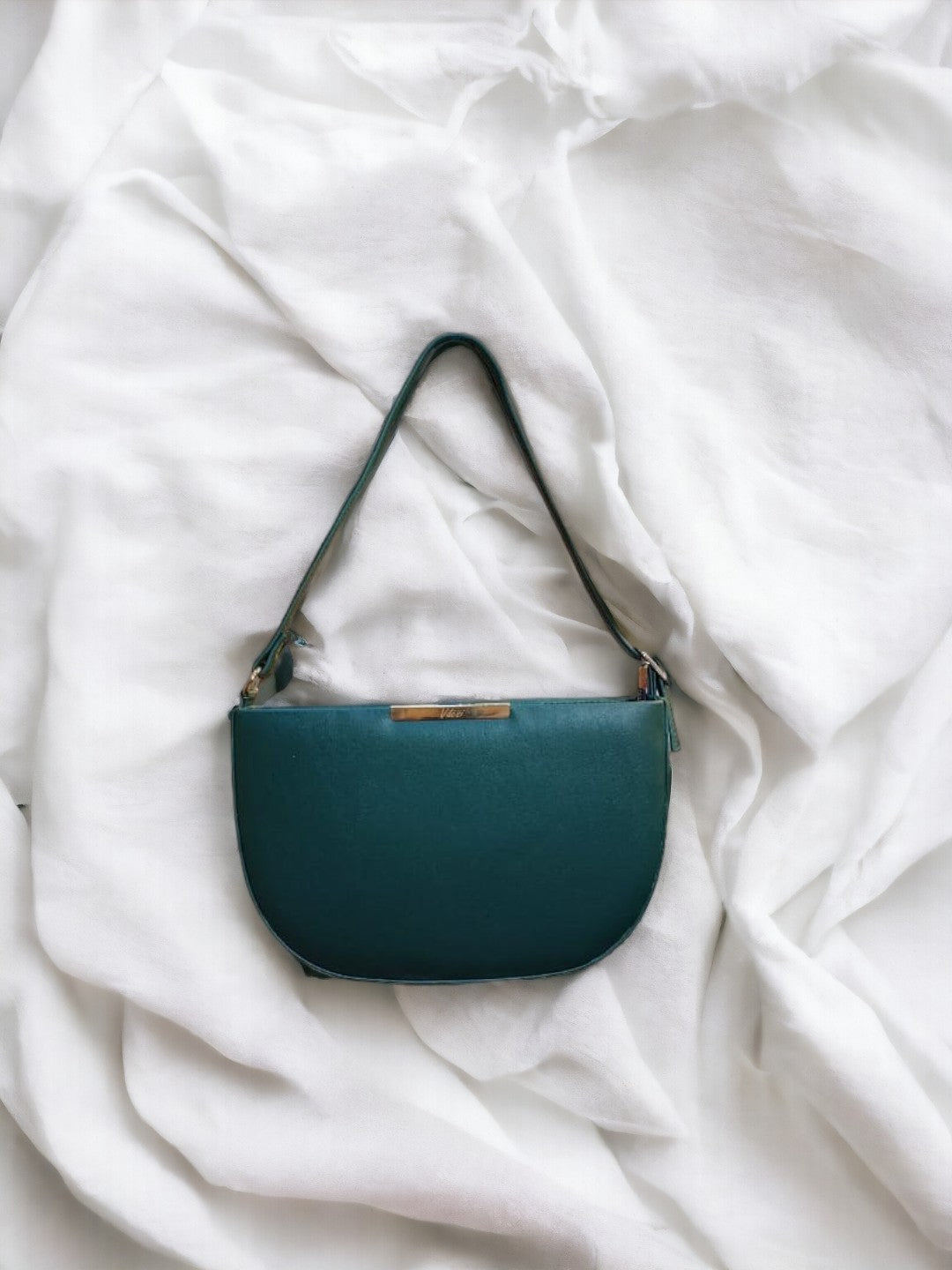 A ladies green shoulder bag on a plain white background. 