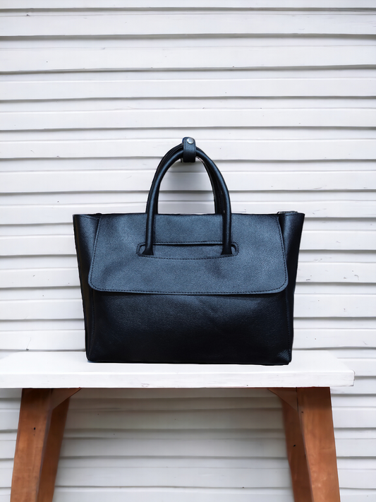 A Vdesi black handbag on a plain white background. 