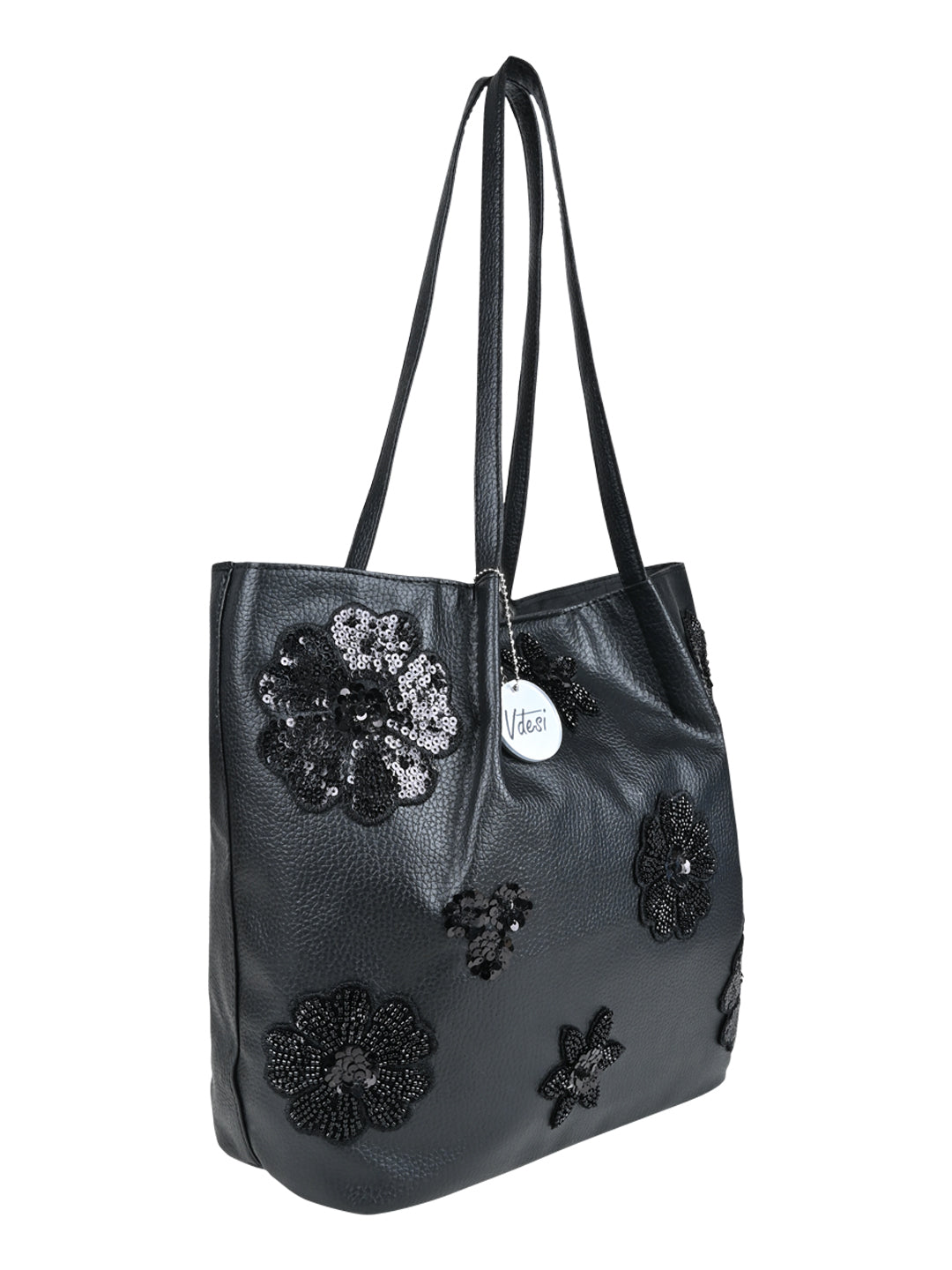 Adorned with a captivating floral pattern against a sleek black backdrop, this tote bag is a timeless statement piece that exudes sophistication and charm. 