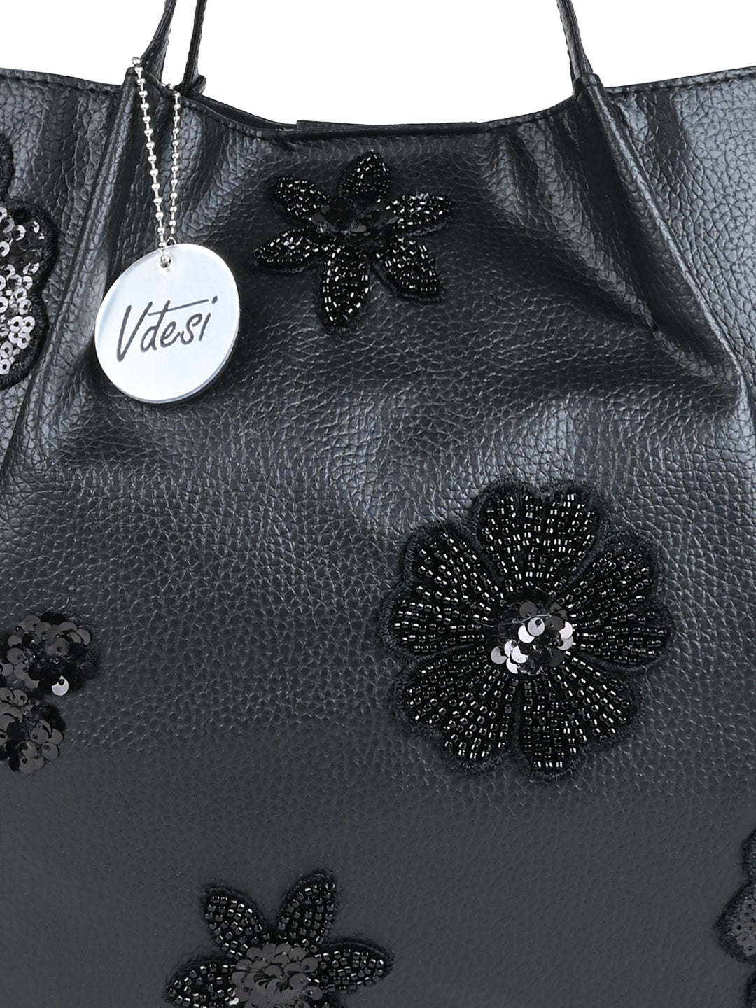 The bold yet delicate floral motif adds a touch of femininity, while the black canvas provides a chic contrast, making it a stylish complement to any ensemble.